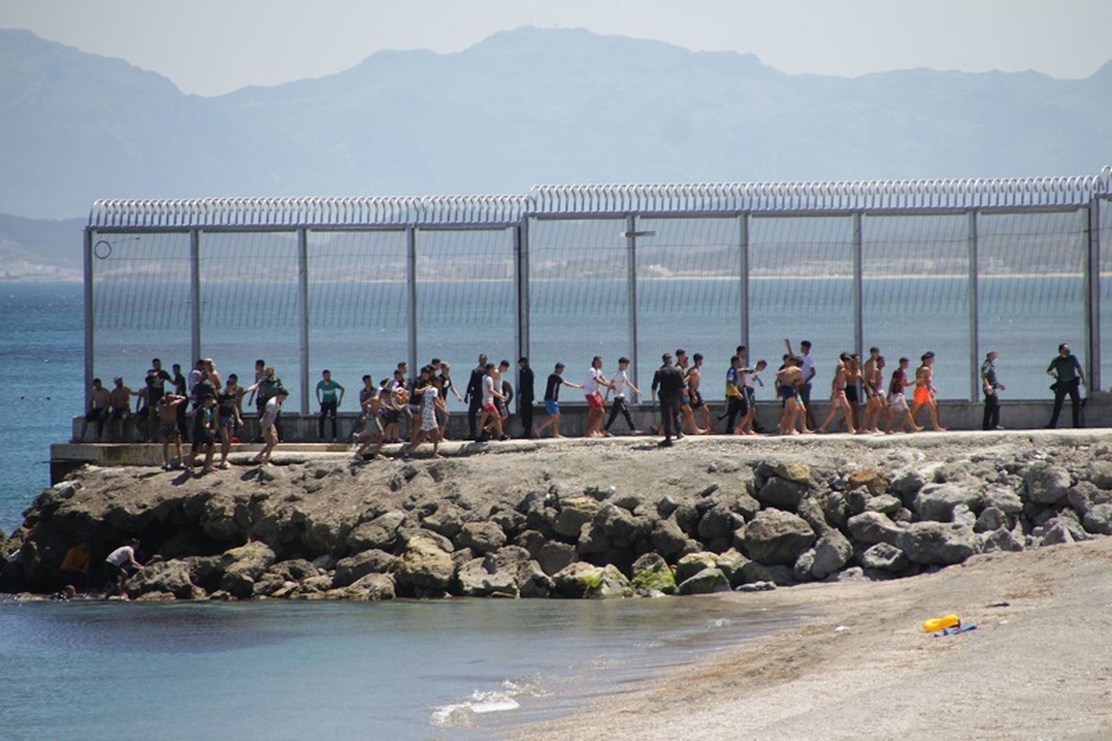 Migrantes caminan sobre el espigón de El Tarajal en mayo de 2021/FOTO EL PUEBLO