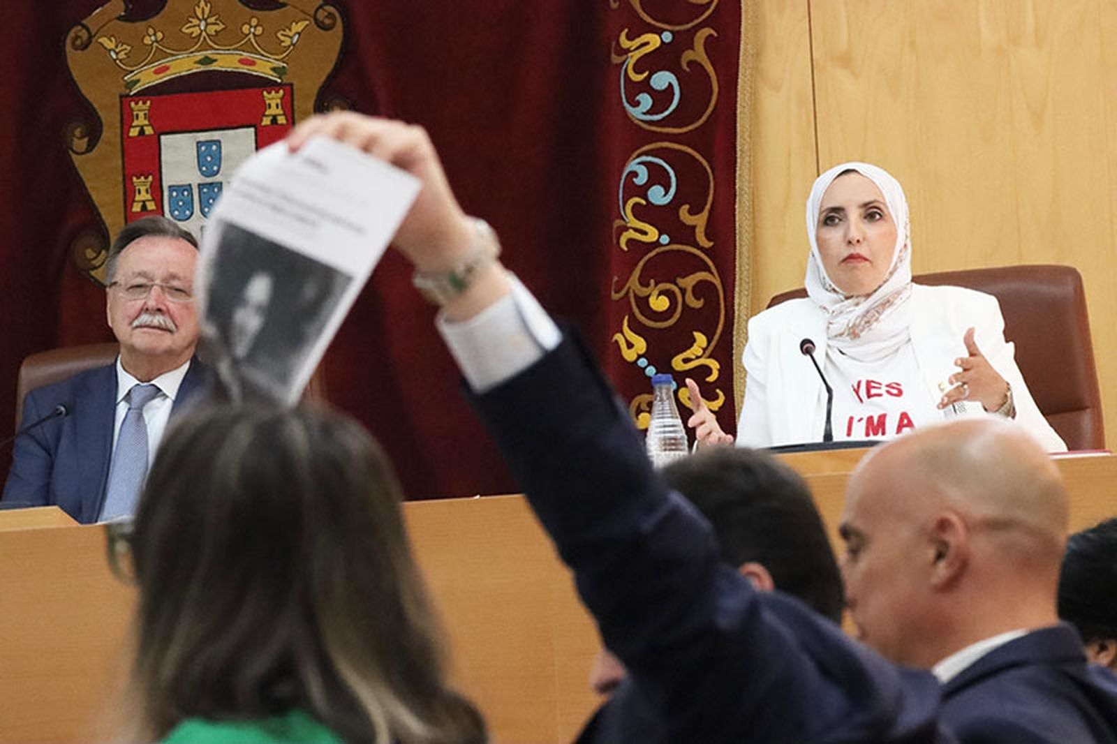 Redondo exhibe un recorte de prensa mientras Hamed interviene ante el pleno/FOTO REDUAN
