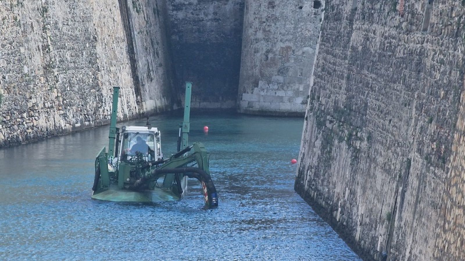 Un trabajador dragando el foso este martes. / FOTO S.D.